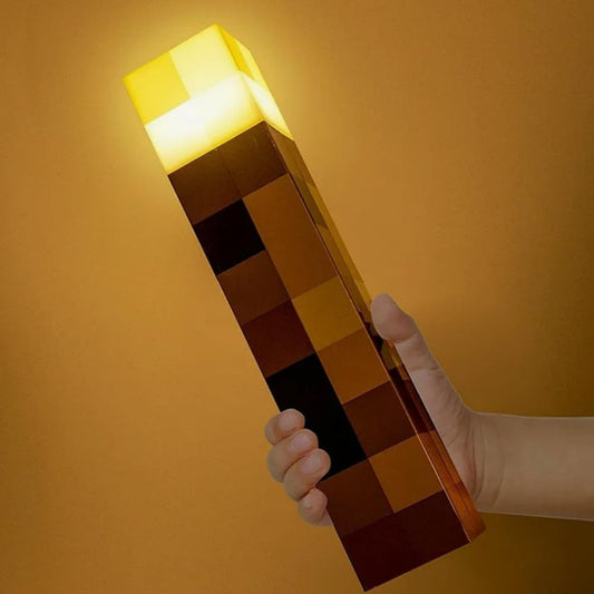 Hand holding a pixelated light-up object against a yellow background
