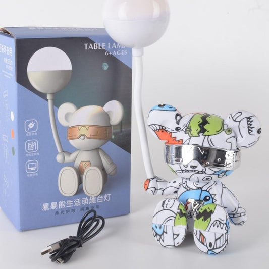 Colorful robot toy with packaging and power cord on a white background